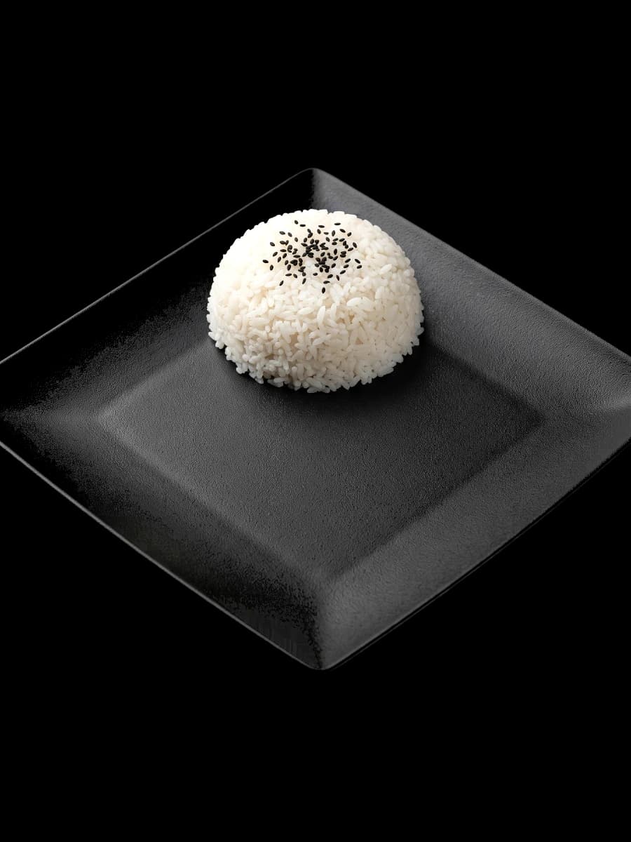 A black plate of steamed rice with black sesame, waiting